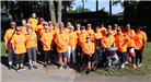 Big group of people in orange shirts that participated in the 5k. 