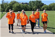 Group of people in orange shirts walking a 5k.