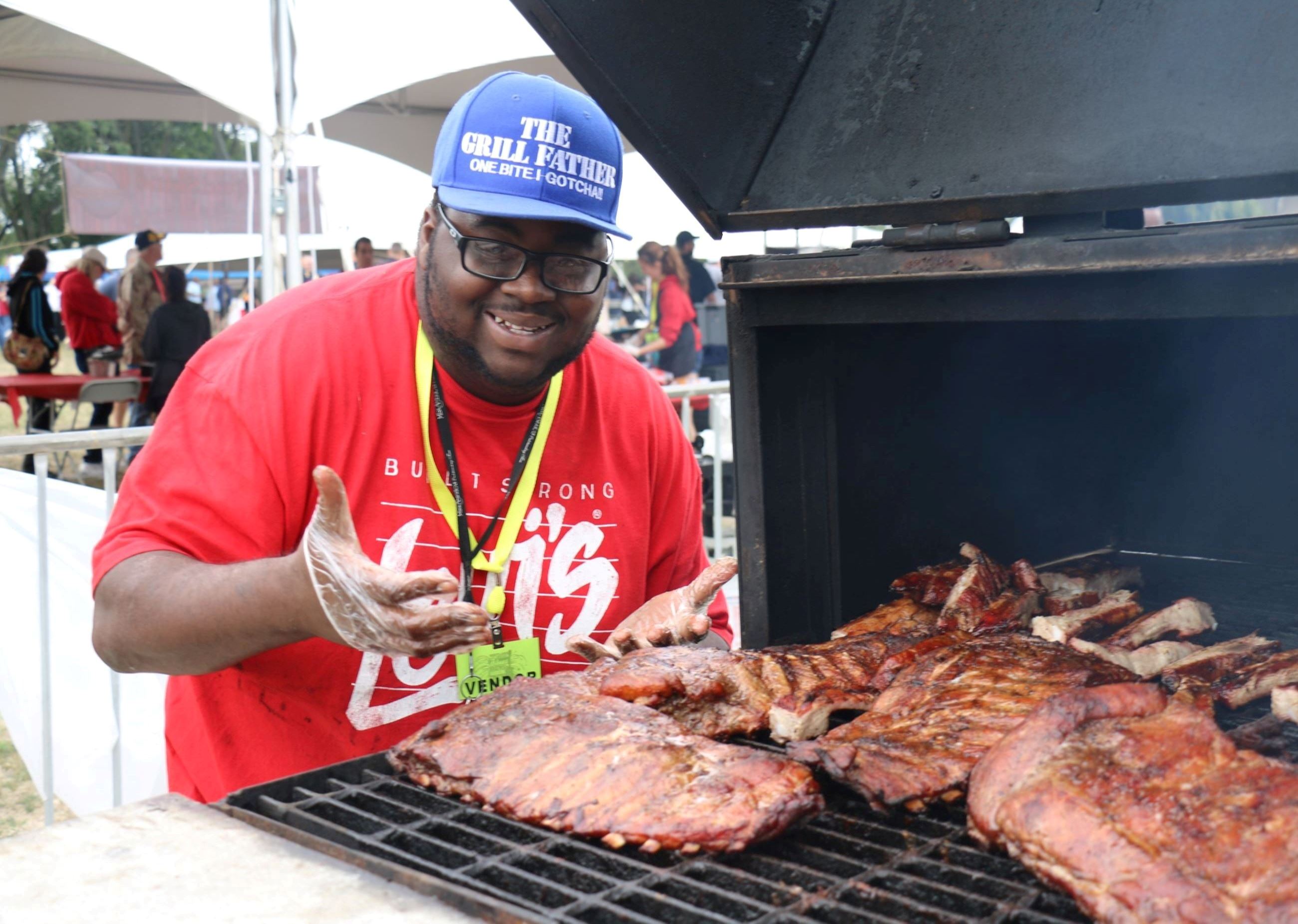 Man with hat cooking rib on BBQ grill